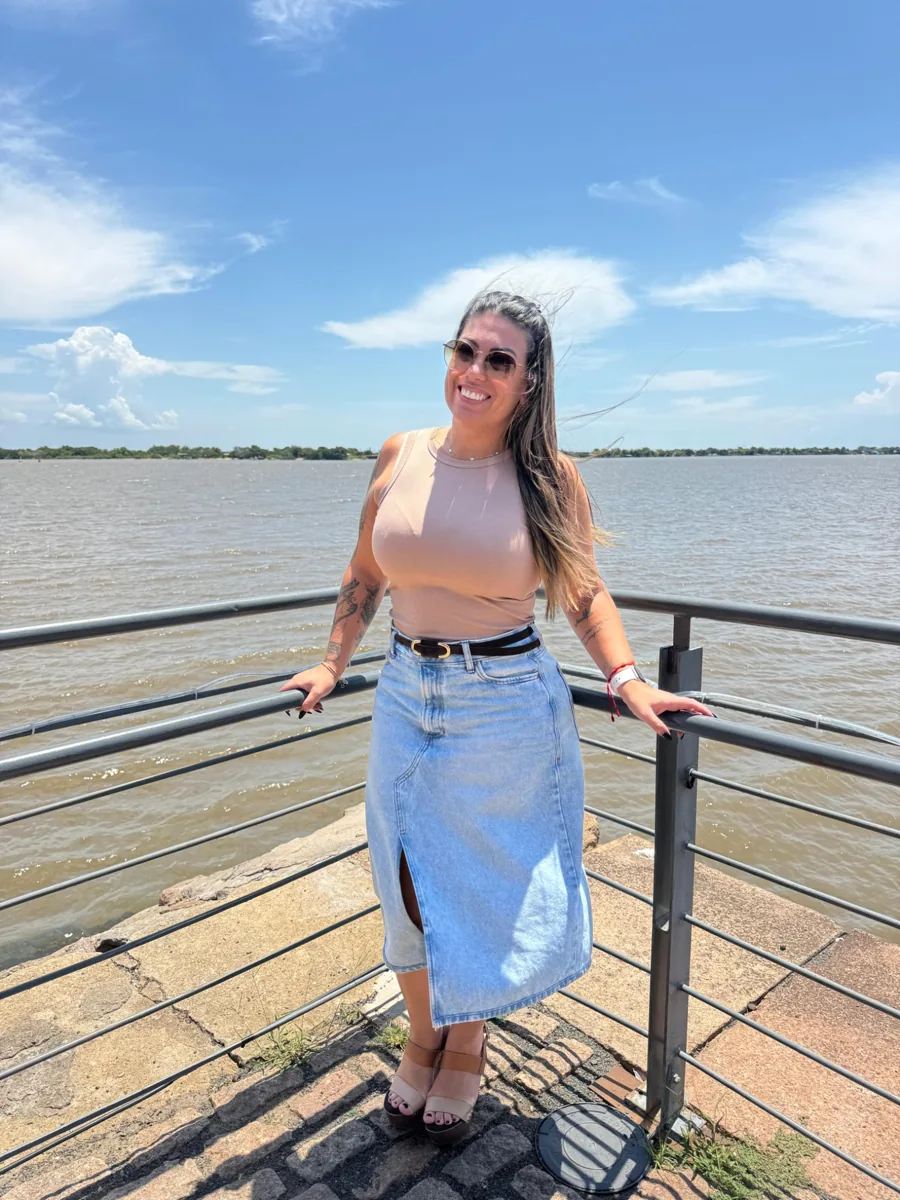 Kelly Guimarães sorrindo à beira d’água, em um registro pessoal.